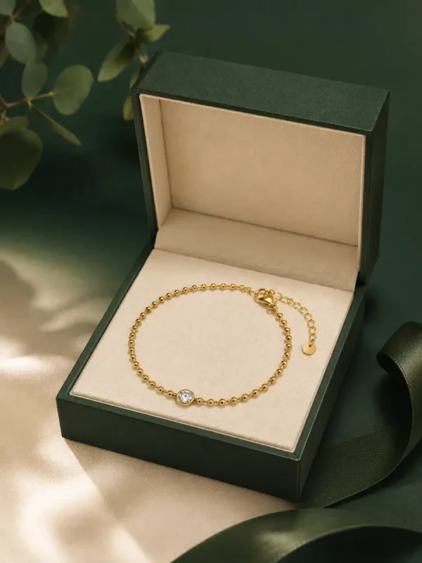 Elara gold beaded solitaire bracelet displayed in green jewellery box