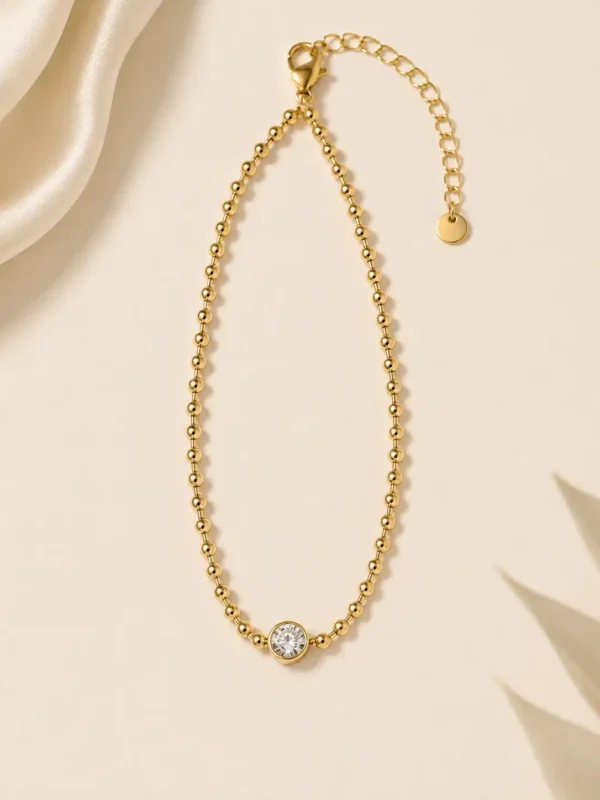 Full view of adjustable gold beaded solitaire bracelet with clasp and extension chain
