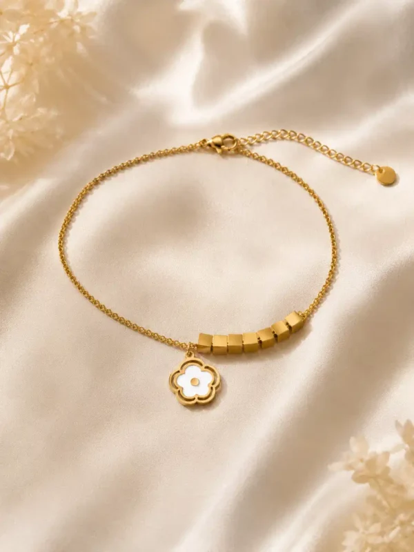 Full view of adjustable gold floral charm bracelet with lobster clasp and extension chain