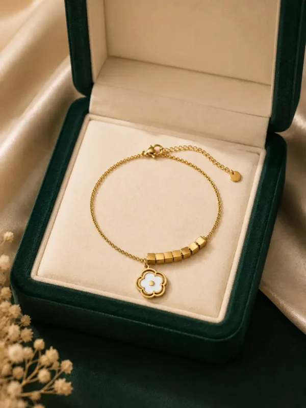 Avira white floral charm bracelet with gold cube accents displayed in jewellery box