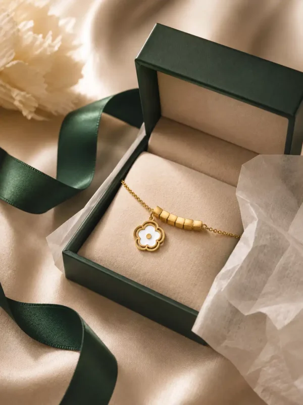 White bloom gold charm bracelet with geometric cube accents in premium jewellery box