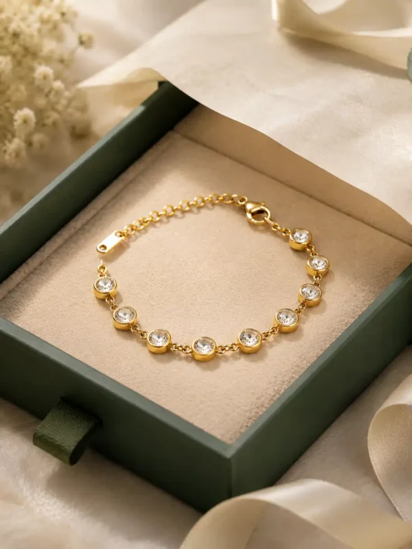 Gold plated bezel tennis bracelet with round CZ stones displayed in jewellery gift box