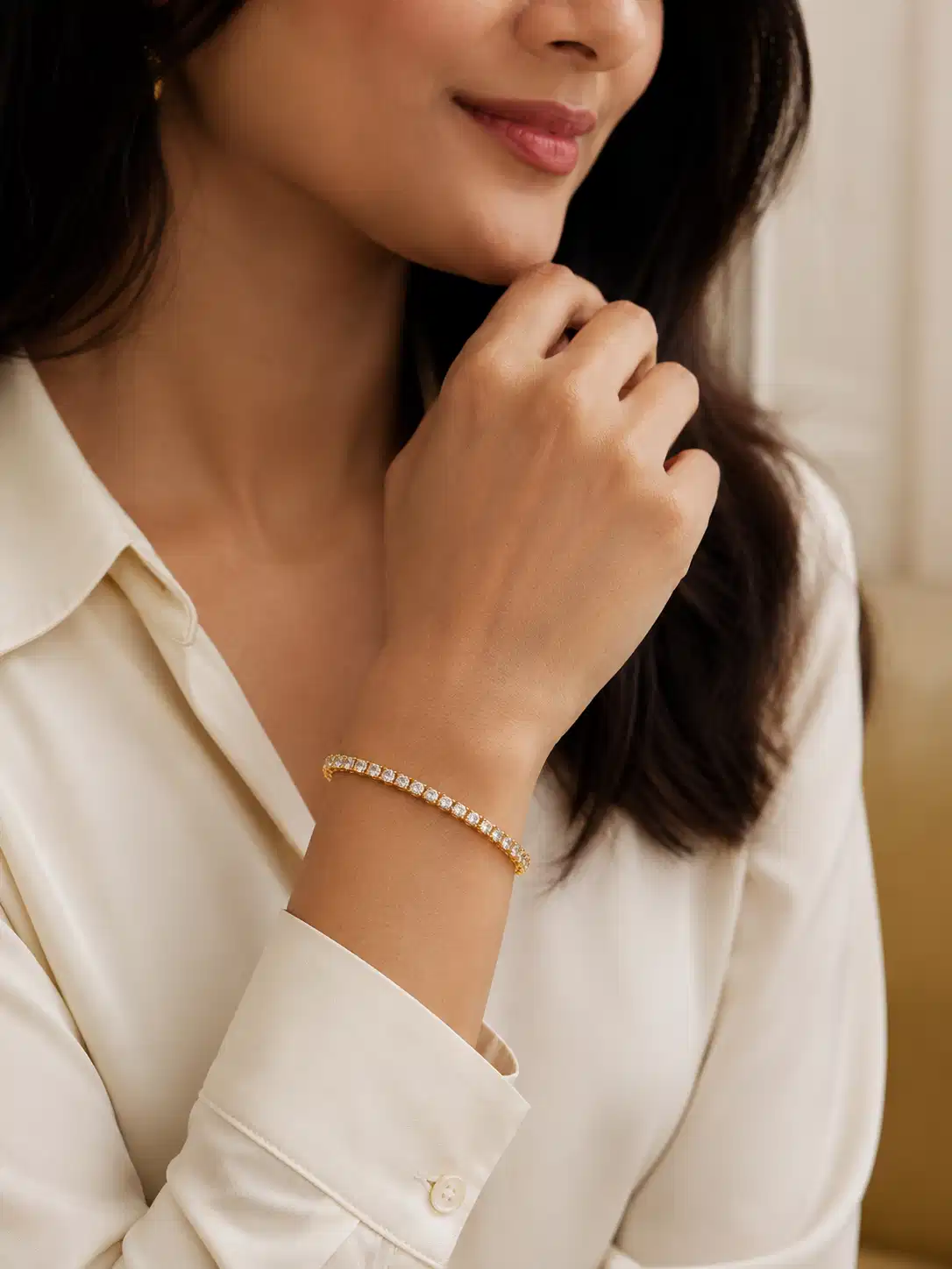 Woman wearing gold plated CZ tennis bracelet with white office shirt