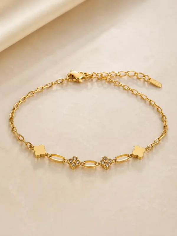Elara gold clover link bracelet with adjustable clasp and crystal charms on neutral background