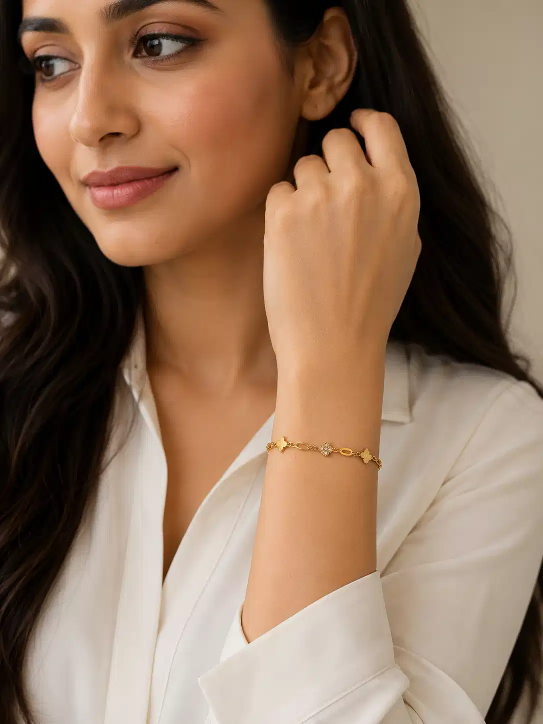 Woman wearing Elara anti-tarnish gold clover bracelet with white office shirt