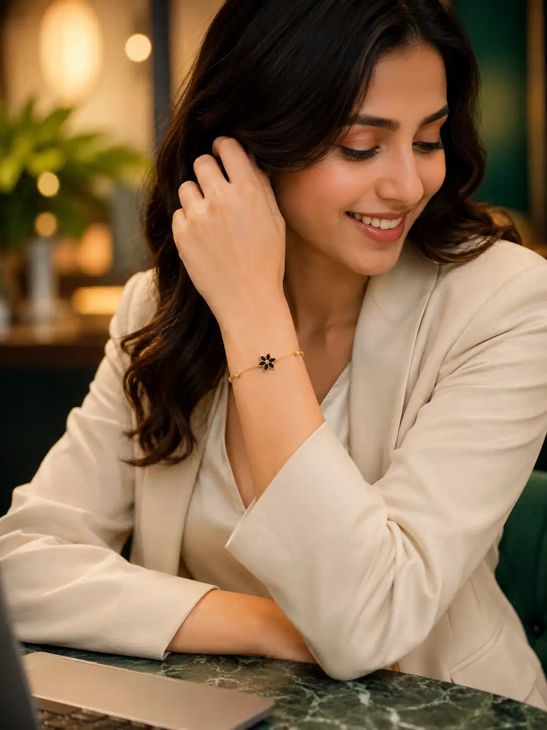 Woman wearing Noir Bloom gold-plated black flower bracelet with cream blazer for office styling