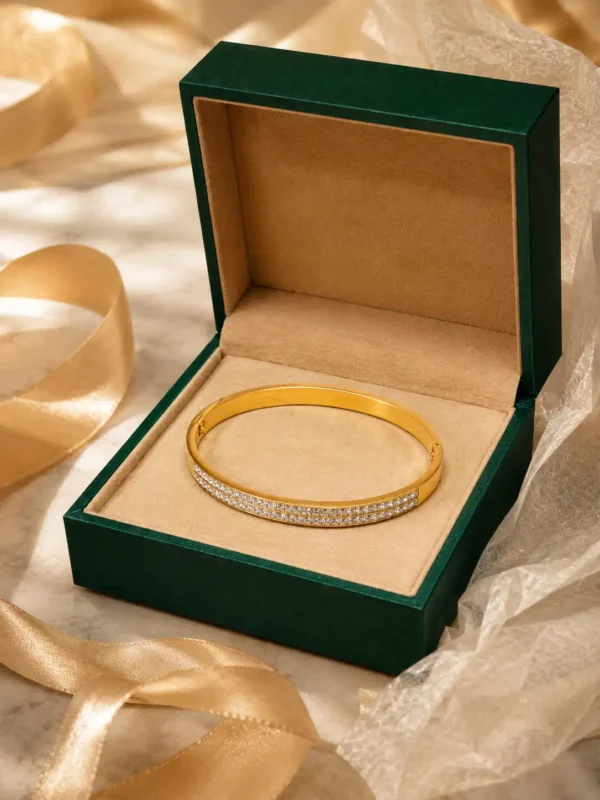 Gold double-row CZ bangle displayed in a green jewellery gift box with satin ribbon