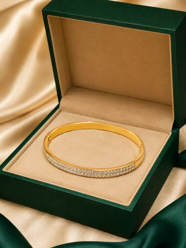 Double-row CZ gold bangle displayed inside a green jewellery box