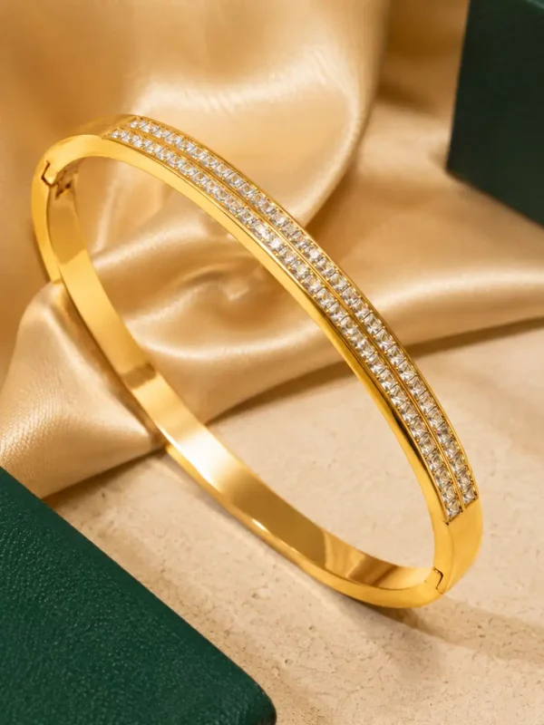 Close-up of double-row cubic zirconia detailing on a polished gold bangle bracelet
