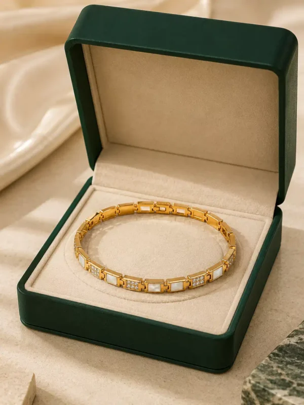 Ivory Glow gold crystal link bracelet displayed inside a green jewellery box
