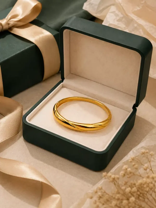 Anti-tarnish twisted gold bangle in a green jewellery gift box with satin ribbon styling