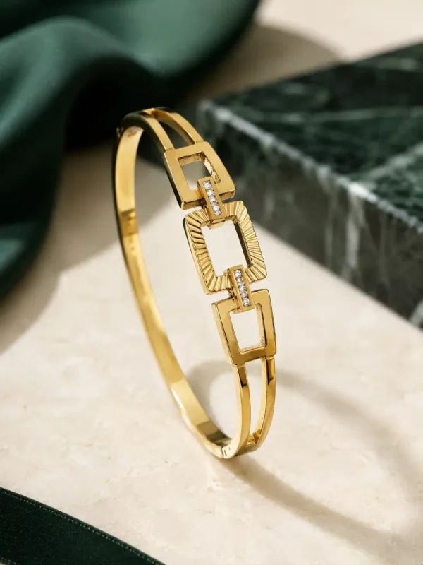 Angled view of anti-tarnish gold geometric link bangle with double band design