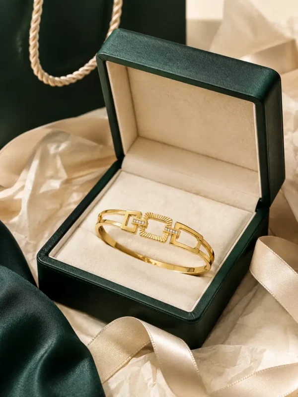Gold geometric crystal bangle displayed in premium green jewellery gift box