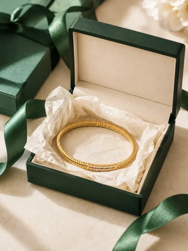 Gold crystal bangle displayed in jewellery gift box with green ribbon