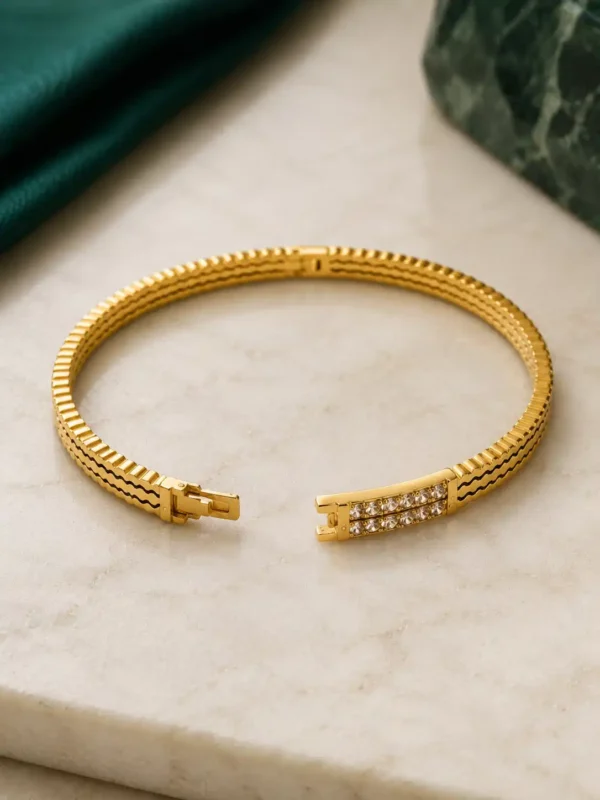 Open anti-tarnish gold crystal bangle showing clasp mechanism and textured band