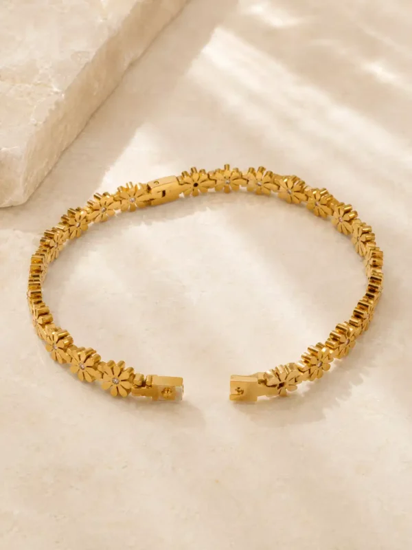 Open Daisy Glow gold floral bangle showing fastening clasp and daisy links