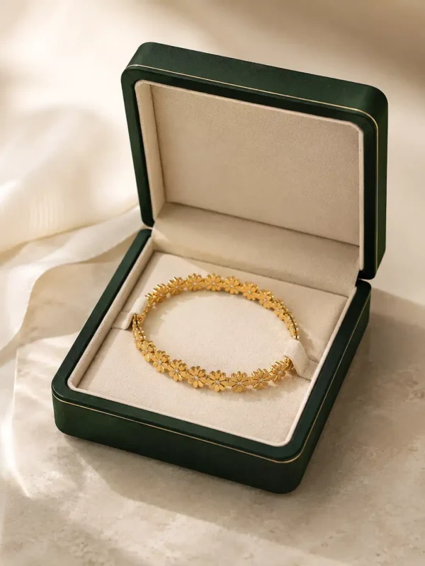 Gold daisy floral bangle styled in green gift box with ribbon presentation