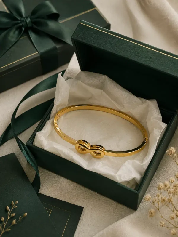 Minimal infinity gold bracelet arranged in an elegant green gift box