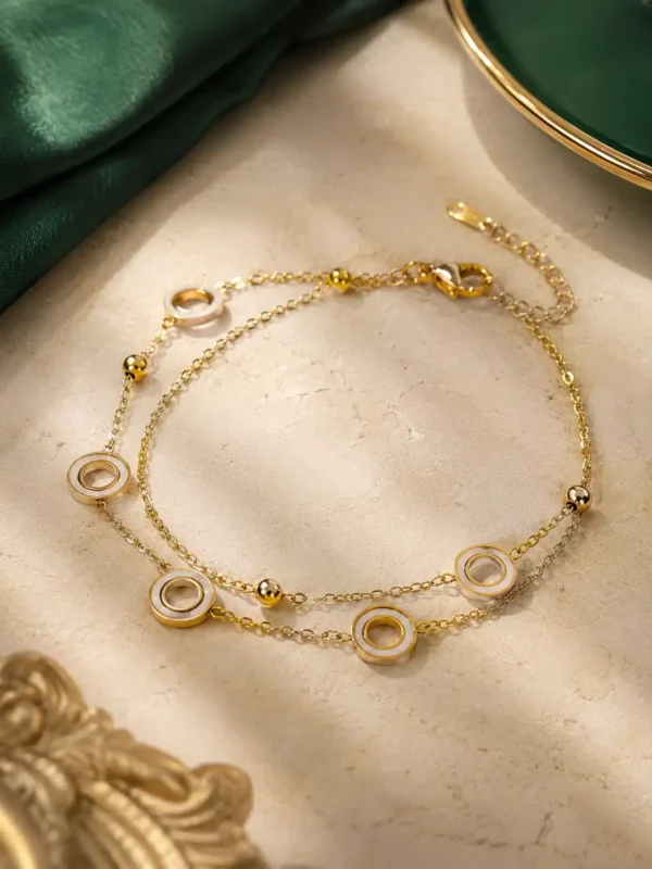 Adjustable double-chain gold bracelet with white circle charms and extension chain