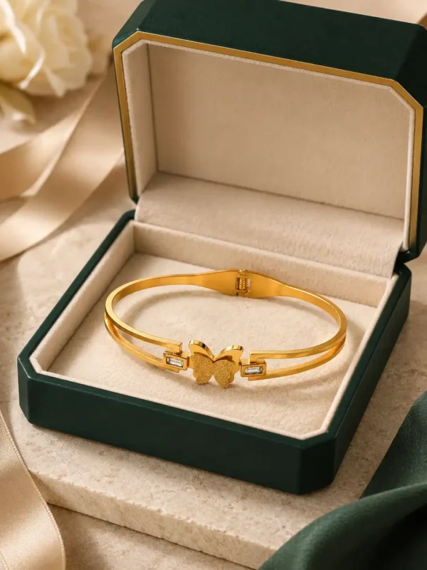 Gold butterfly crystal bangle displayed inside a premium green jewellery box