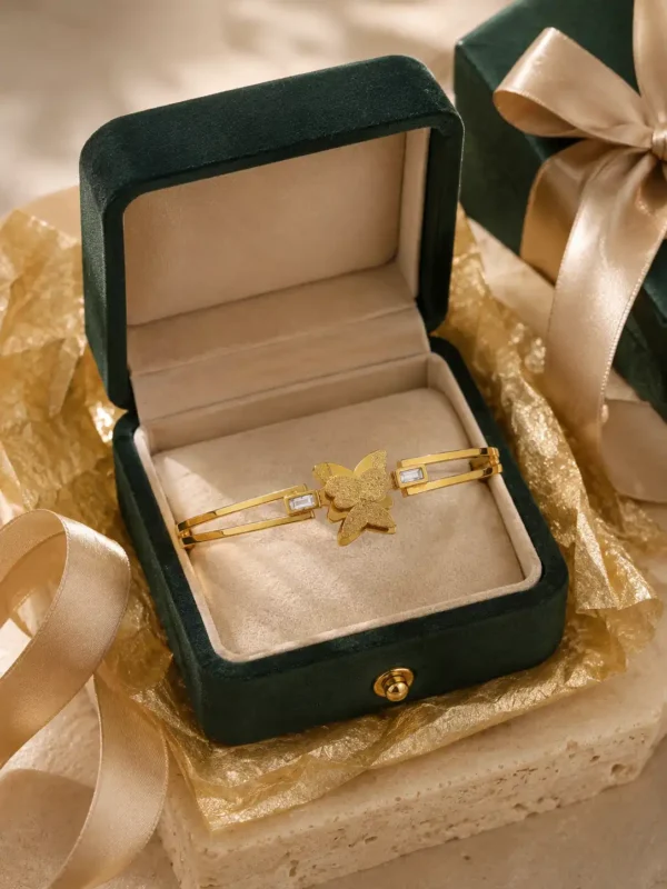Butterfly gold bangle with crystal accents presented in a green jewellery gift box with ribbon