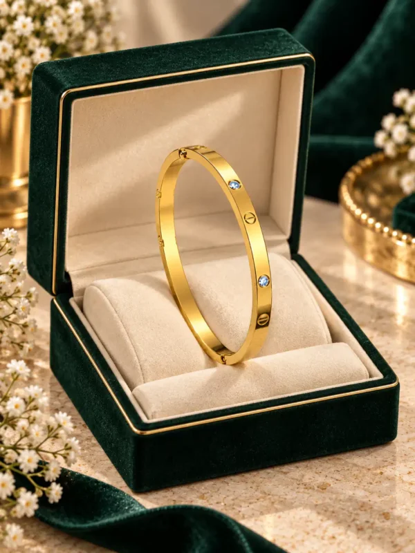 Gold screw crystal bangle displayed in a green jewellery presentation box
