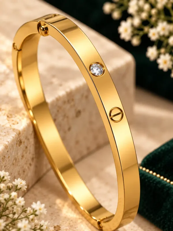 Close-up of gold bangle with round crystal stone and screw-head detail