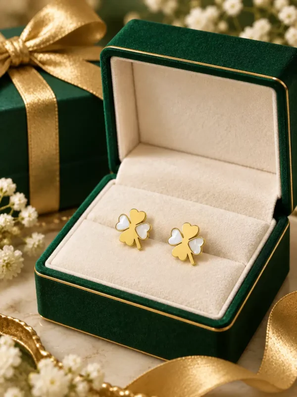 Mother-of-pearl clover stud earrings displayed in a green jewellery box with gold ribbon
