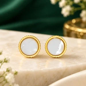 Gold-plated mother-of-pearl stud earrings with round white centres and fluted gold bezel