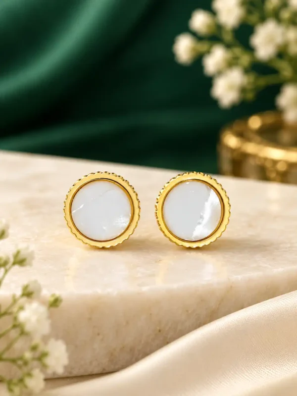 Gold-plated mother-of-pearl stud earrings with round white centres and fluted gold bezel