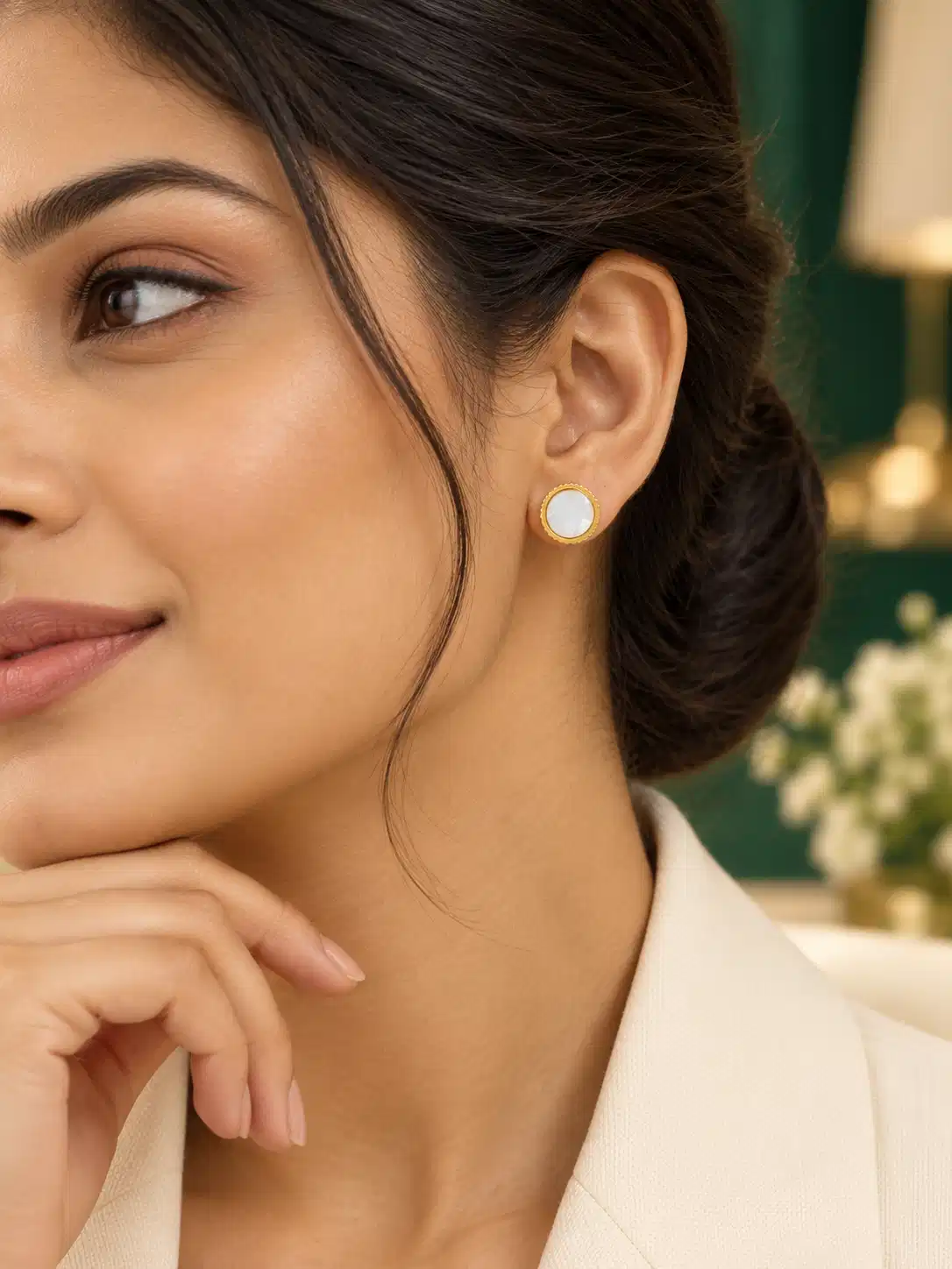 Woman wearing petite gold mother-of-pearl stud earrings with office wear