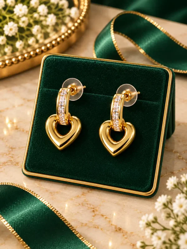 Gold heart crystal drop earrings displayed on a green jewellery stand