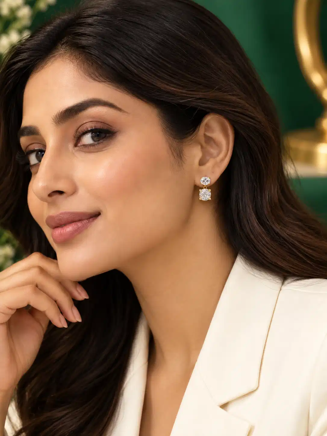 Woman wearing Celeste gold-plated double crystal drop earrings with a white blazer
