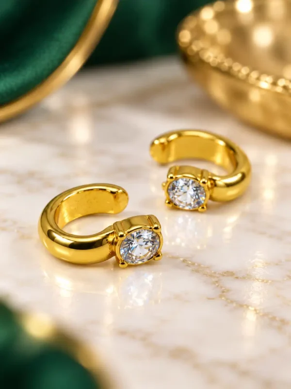 Angled view of gold solitaire CZ ear cuffs showing polished open curved design