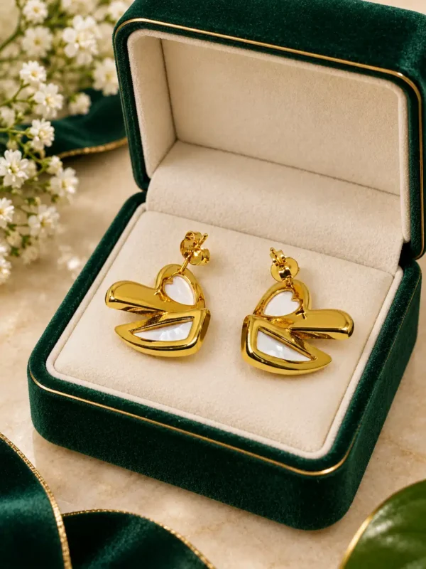 Ivory Sculpt anti-tarnish gold heart stud earrings with white mother-of-pearl accents in a green jewellery box