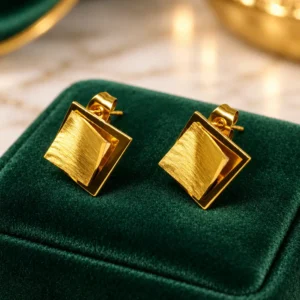 Anti-tarnish gold-tone layered square stud earrings with brushed centre on green velvet