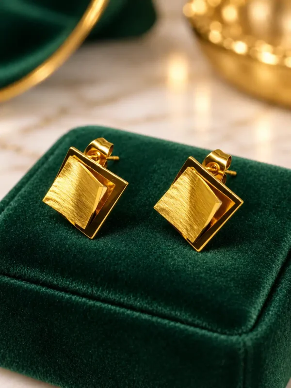 Anti-tarnish gold-tone layered square stud earrings with brushed centre on green velvet