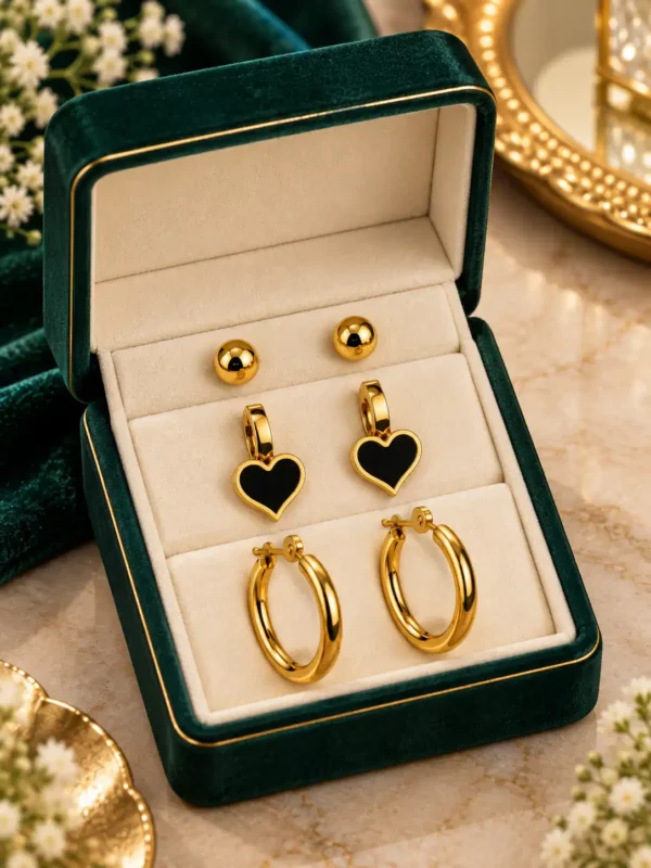 Gold-plated 3-pair earring set arranged with ball studs, black heart earrings and hoops