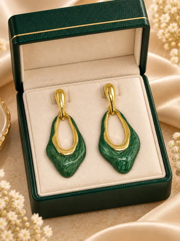 Pair of green enamel geometric drop earrings displayed in a cream and green jewellery box
