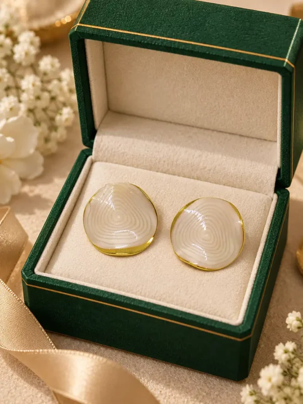 Ivory Ripple anti-tarnish stud earrings displayed in green jewellery box with polished gold-tone border