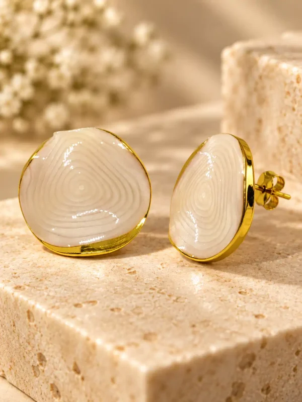 Side and front view of ivory marble-look stud earrings showing gold-tone edge, post and push-back closure