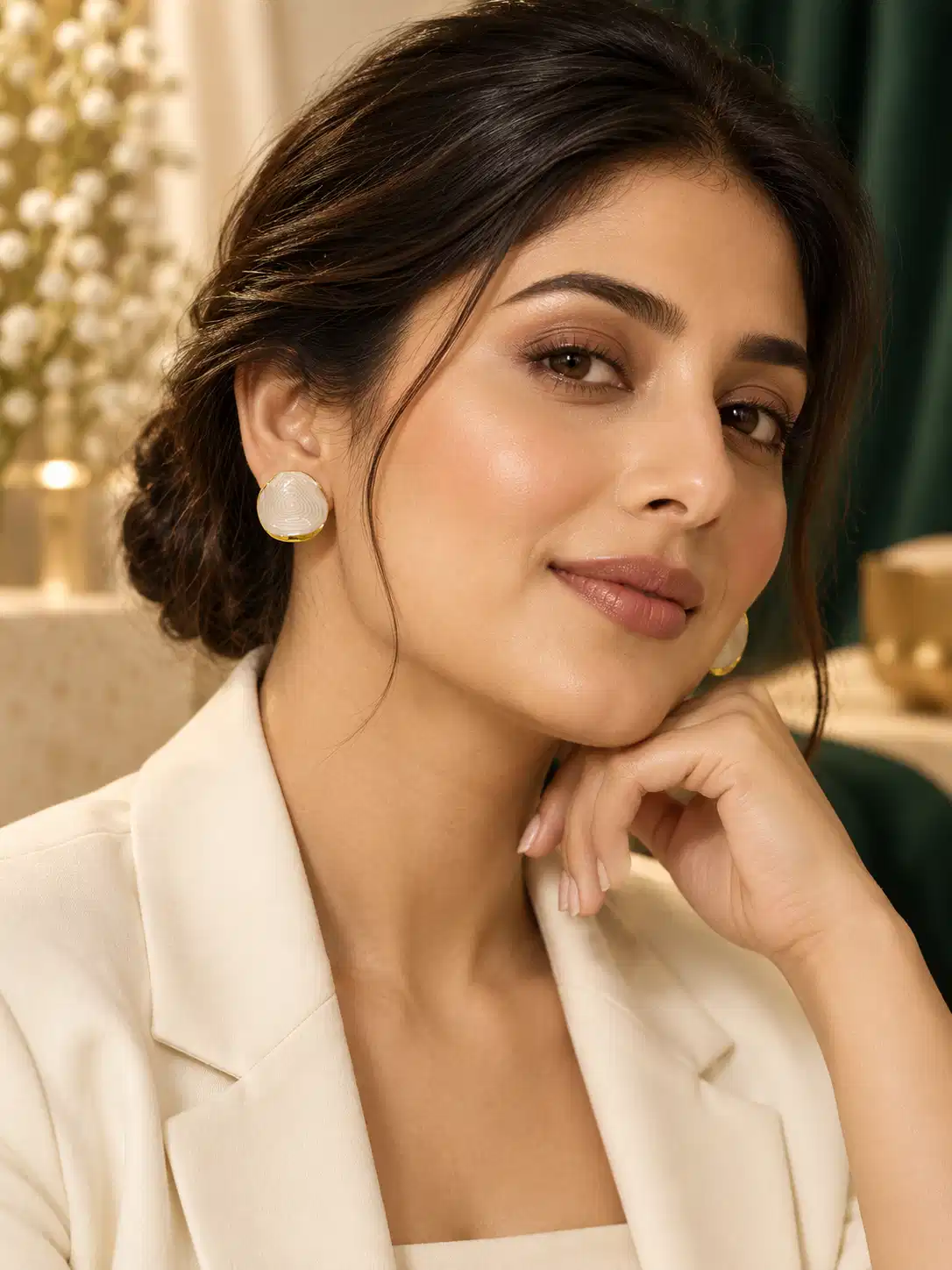 Woman wearing ivory marble-look stud earrings with gold-tone edging and white blazer for office wear