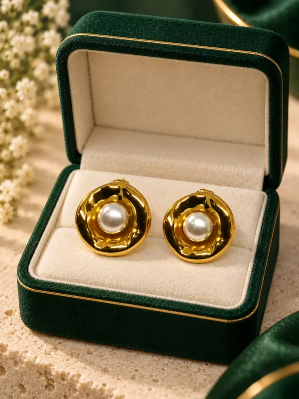Mira gold pearl stud earrings displayed in green jewellery box