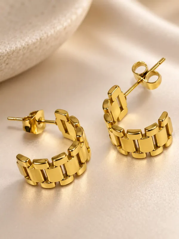 Close-up of gold-plated segmented watch-link hoop earrings with push-back closure