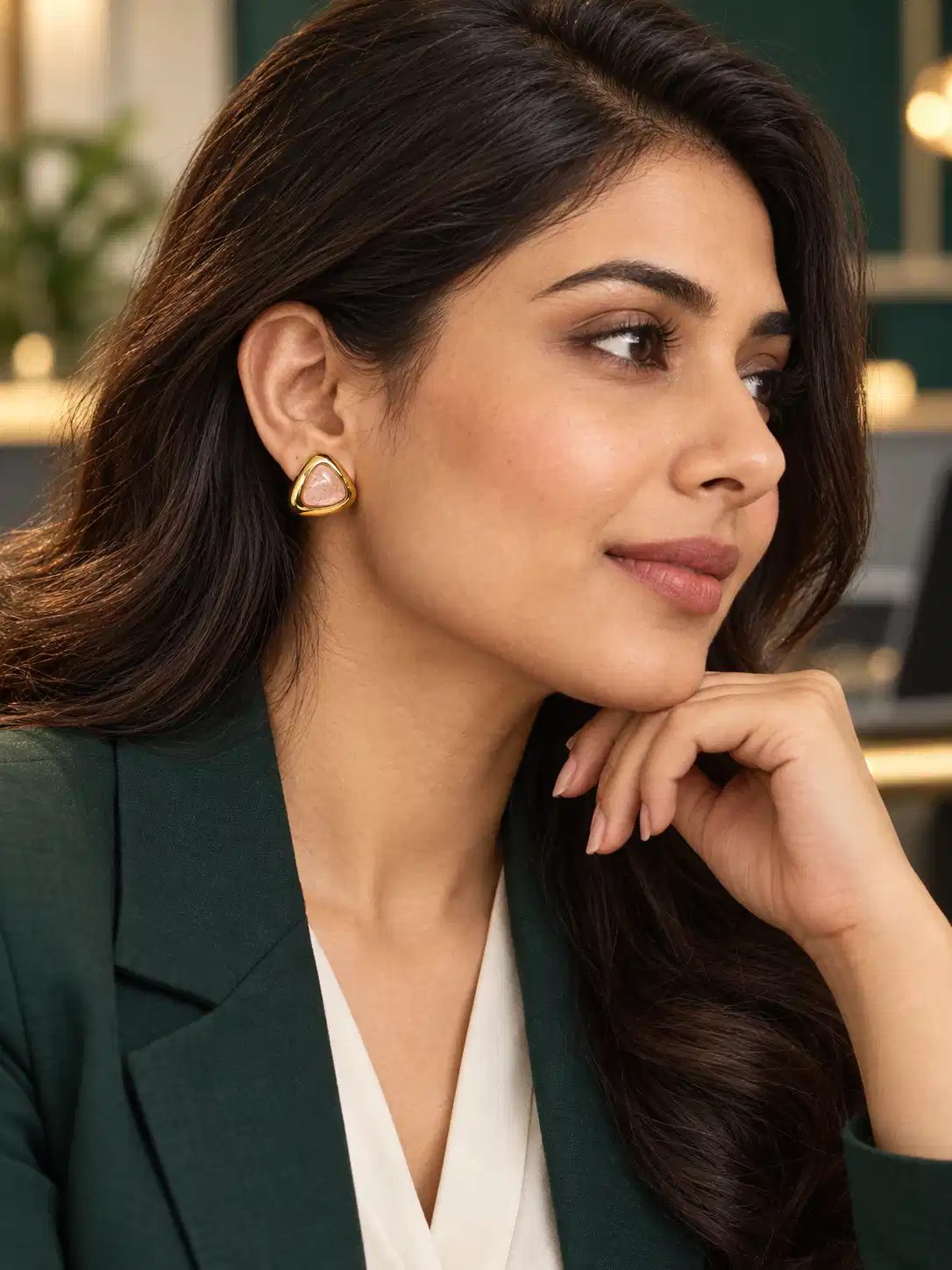 Woman wearing Aurelia pink and gold stud earrings with office blazer