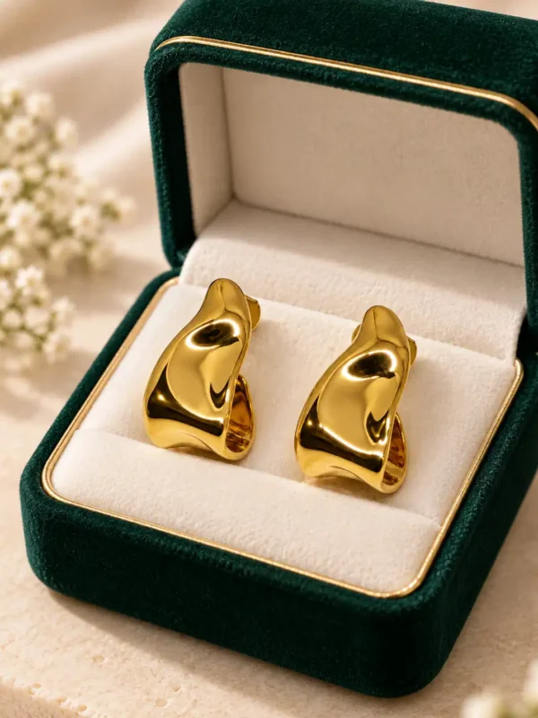 Amara anti-tarnish gold half hoop earrings displayed in a green jewellery box