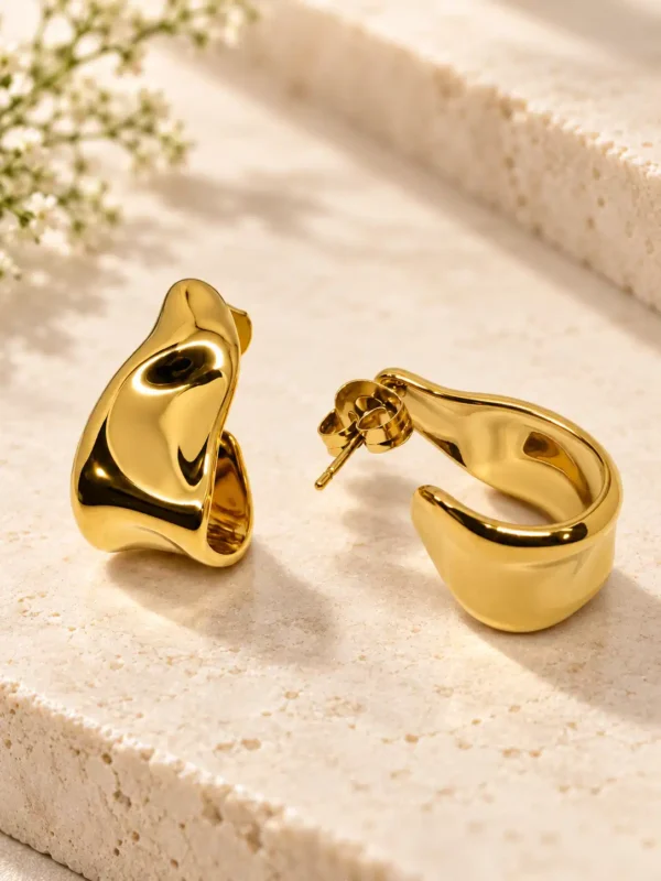 Amara gold half hoop earrings showing sculptural side profile and push-back closure