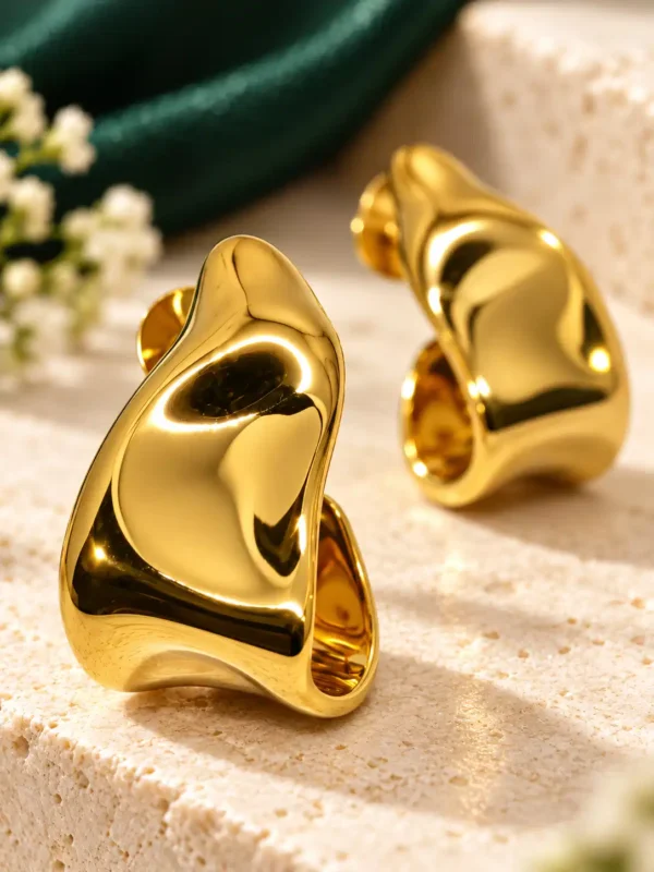 Close-up of Amara molten gold sculptural half hoop earrings for women