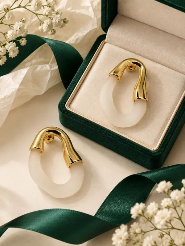 Gold and ivory sculpted hoop earrings styled with green ribbon and flowers