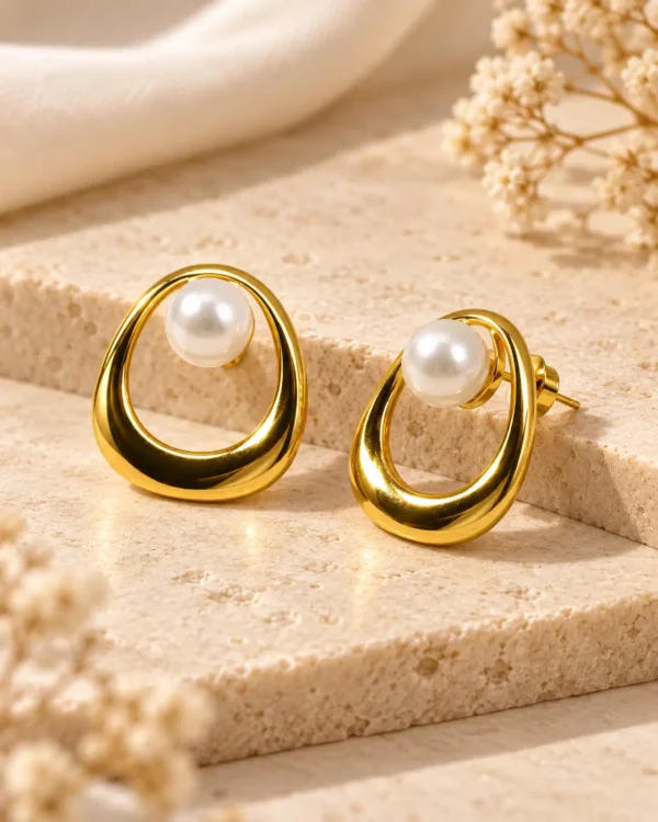 Angled view of Elara pearl stud earrings showing gold open-loop frame and push-back fastening